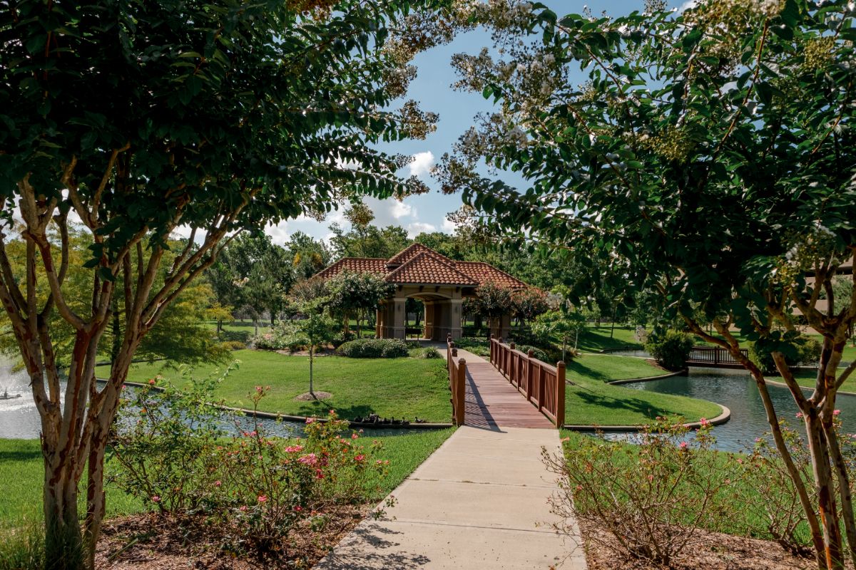 Garden with a bridge and creek at The Hamptons at Meadows Place